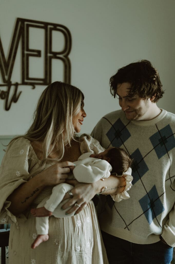 Mom holding baby looking at dad