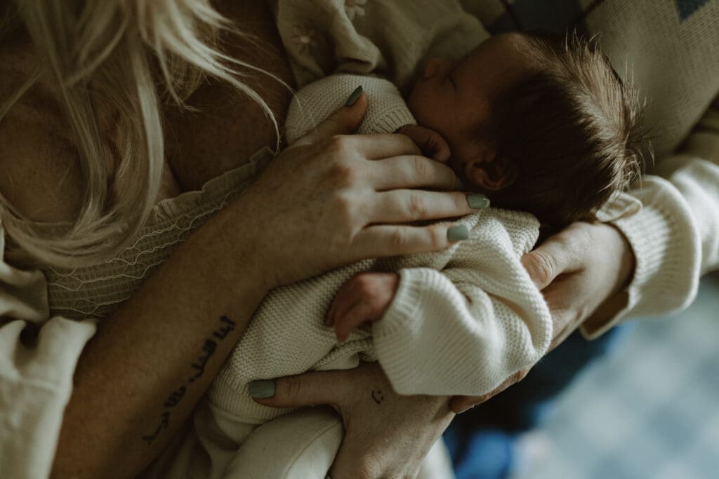 Baby asleep cuddled in parents arms