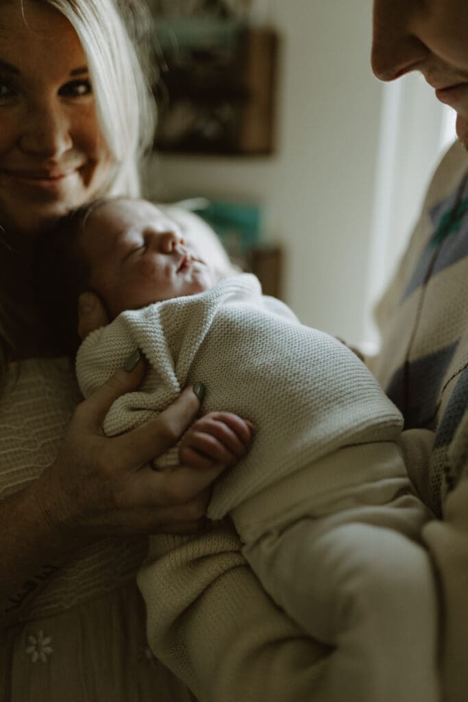 Baby asleep cuddled in parents arms